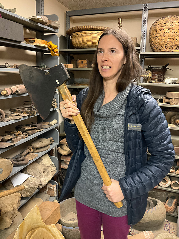 Jessica Shea holding a large axe, a potential artifact from the Santa Barbara Mission era.